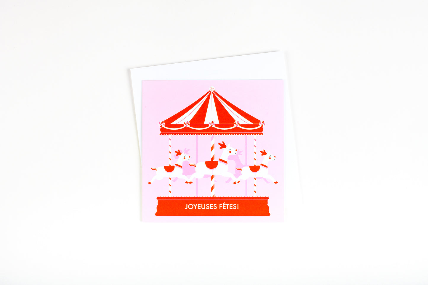 Carte de souhait illustration carrousel de Noël rose et rouge bonbon avec trois rennes écrit Joyeuses Fêtes.