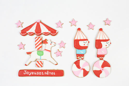 Boite de 17 biscuits: renne dans un carrousel rouge et blanc style bonbon, 8 etoiles, 2 lutins et deux bonbons. Personnalisez un des biscuits avec votre message.